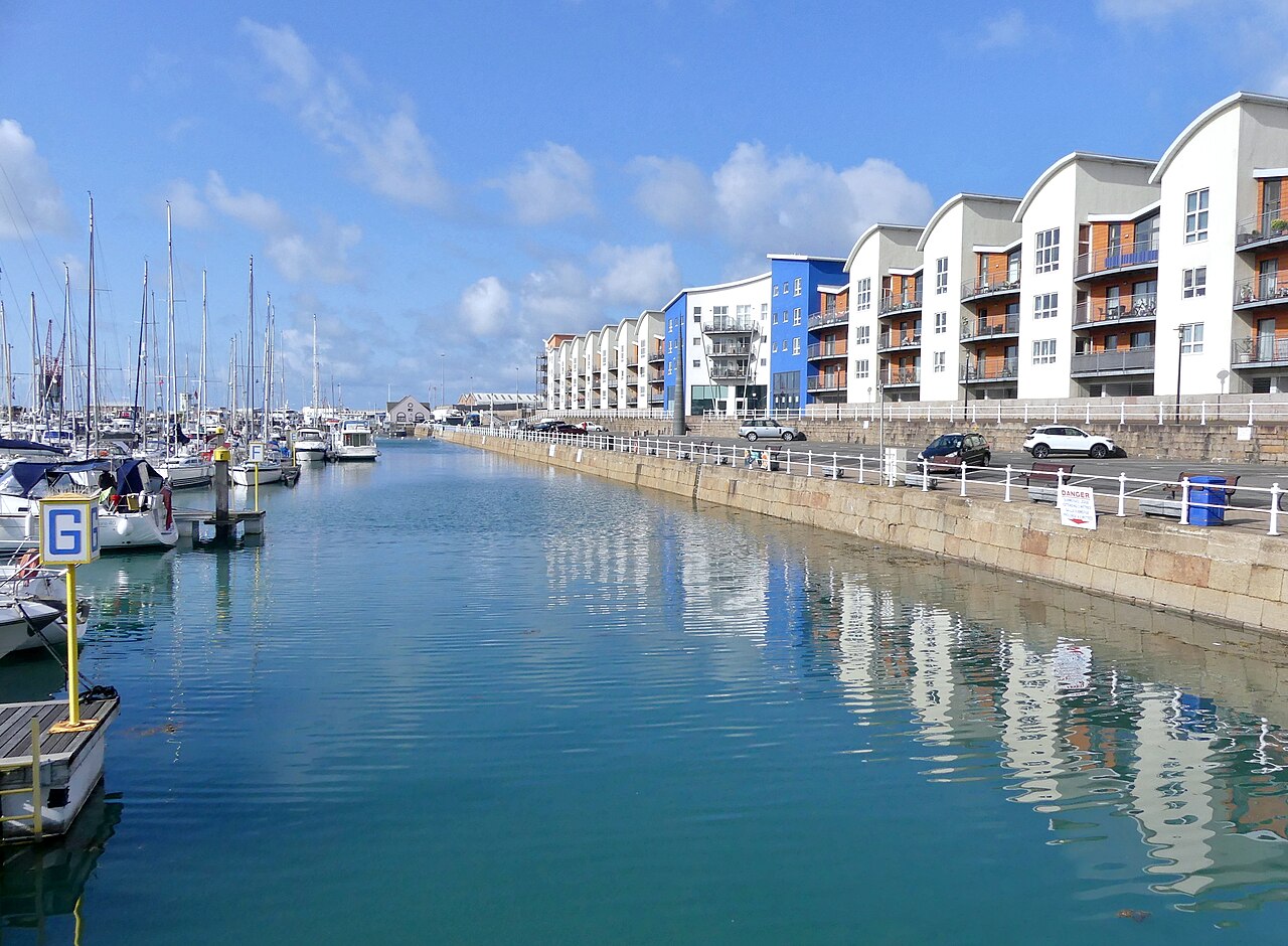 Boats and waterfront buildings reflected in St Helier marina, Jersey